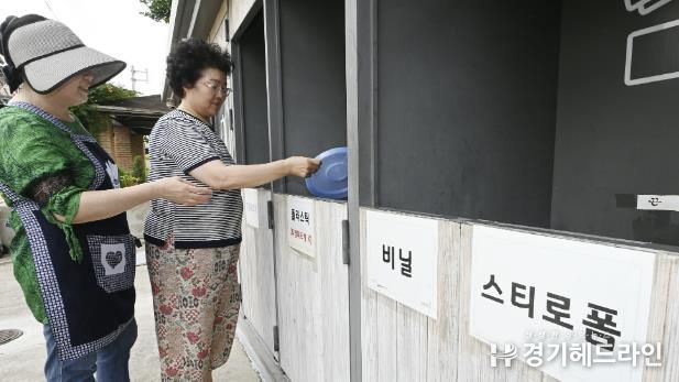 수원특례시 권선구 세류2동 자원순환역에 배치된 관리자가 주민에게 분리배출을 지도하고 있다.