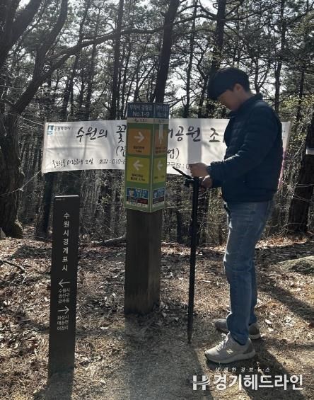 수원특례시 관계자가 GNSS를 활용해 칠보산 인근에 설치된 안내시설물의 위치정보를 측정하고 있다