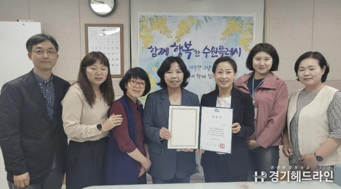 김은주 수원특례시 여성가족국장(오른쪽 3번째)과 직원들이 표창장을 들고 기념촬영을 하고 있다.