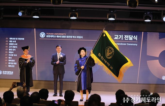 장은영 총장이 최상후 유한학원 이사장에게 전달받은 교기를 힘차게 흔들고 있다.