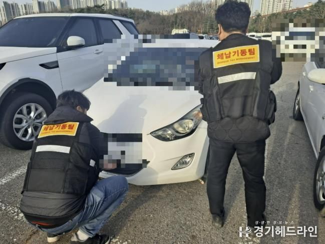 안산시 체납기동팀이 체납차량에 대한 번호판 영치 작업을 진행하고 있다.
