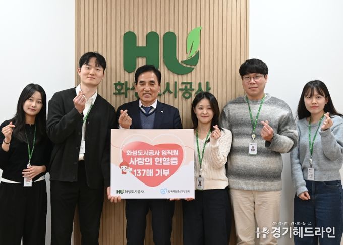 화성도시공사 한병홍 사장이 임직원들이 자발적으로 기부한 헌혈증 전달을 알리는 판넬을 들고 기념촬영을 하고 있다.